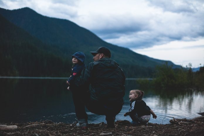 man-with-two-kids-near-body-of-water-1157398