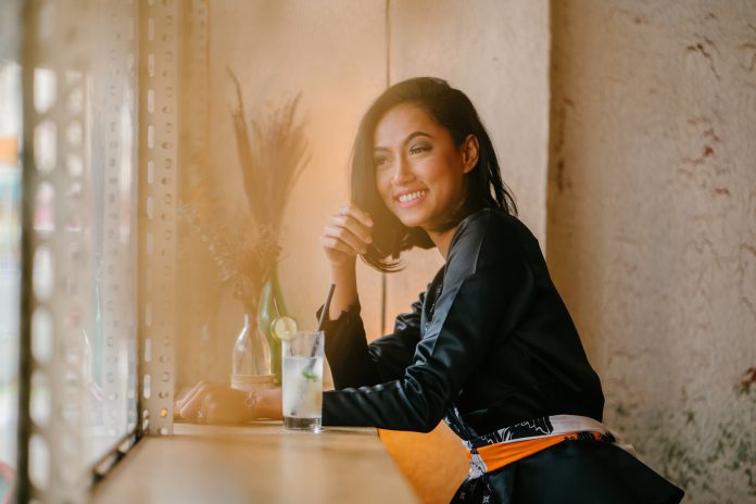 woman-sitting-on-bar-chair-near-clear-drinking-glass-1292684