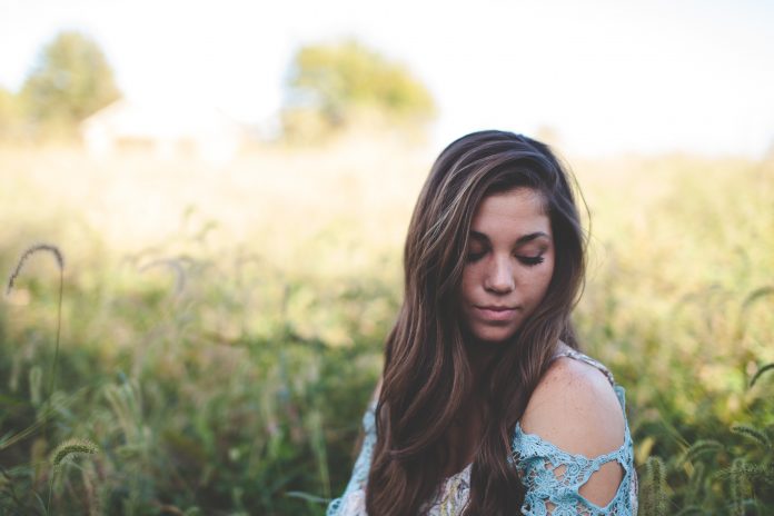 woman-wearing-teal-off-shoulder-while-seating-on-grass-photo-227310